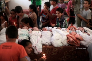 ‫‏صور‬: الاحتفال بمواليد جديدة ولدت خلال أسبوع في مركز إيواء للنازحين من بيوتهم المدمرة بأحد مدارس الأونروا في قطاع ‫‏غزة‬